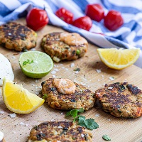 Tuna fish cakes on board with coriander and lemon